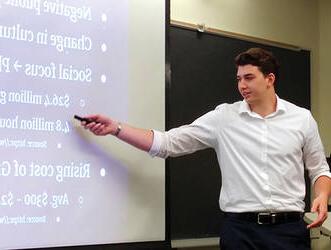 A male "Launch Your 业务" program entrepreneur presenting to an audience.